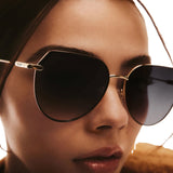 Zoomed in model wearing Main Character Oversized Flat-Top Rounded Sunglasses Black Gold Frame/Smoke - 3/4 angle